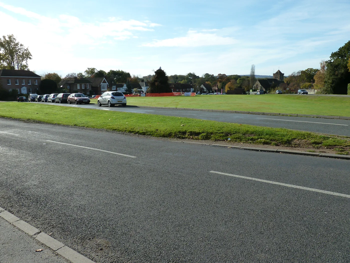 Chiddingfold village green from the A283, with the bonfire site fenced off beyond the cars
