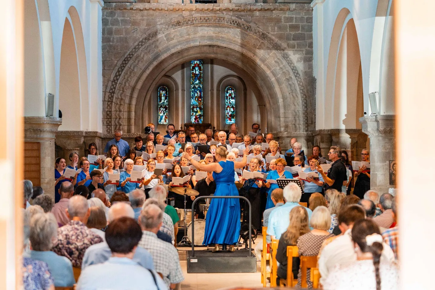 Luminosa choir singing in concert, with the audience seated in the nave