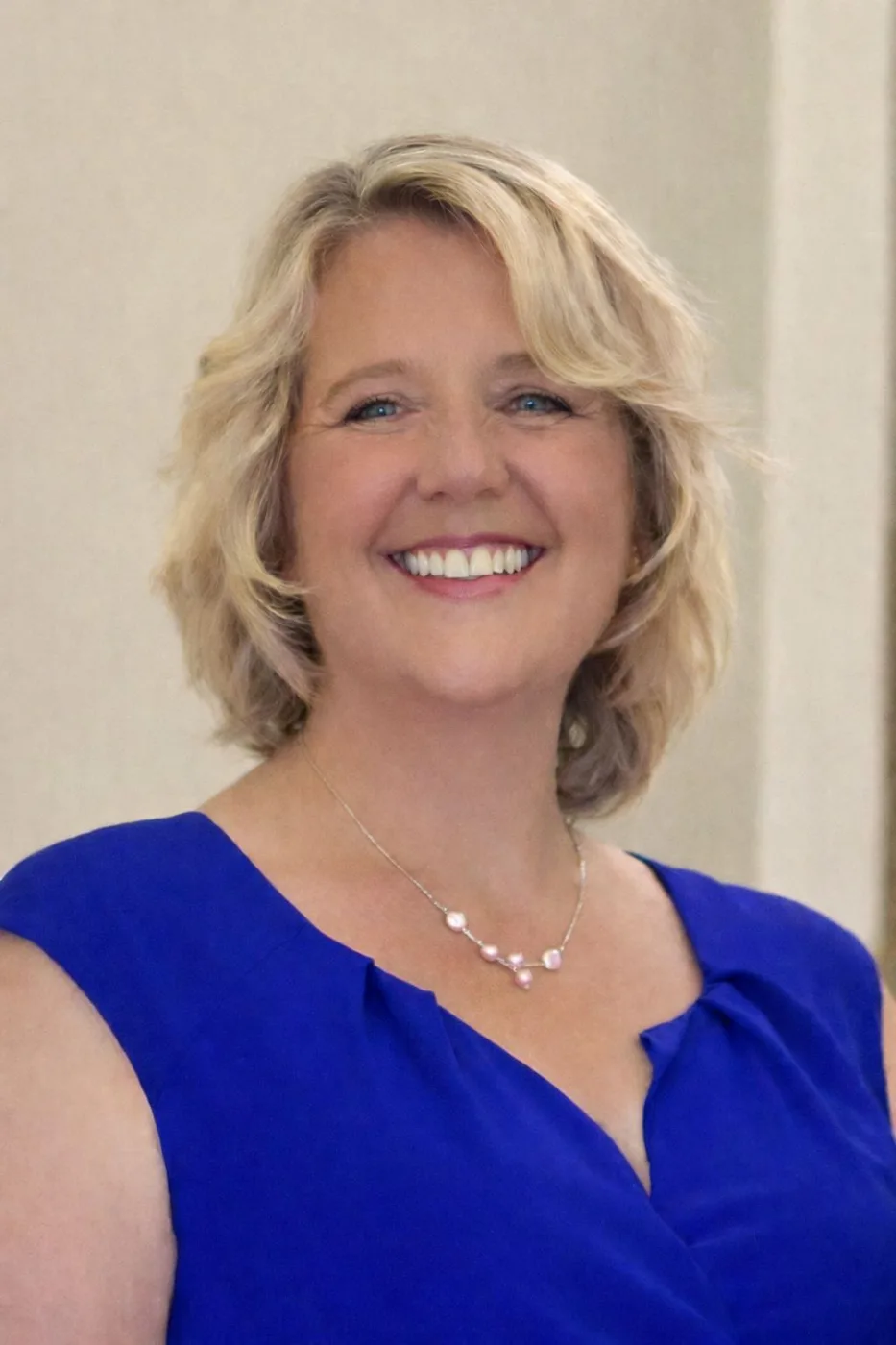 Portrait of Cindy, a Surrey foster carer, smiling, in a blue top
